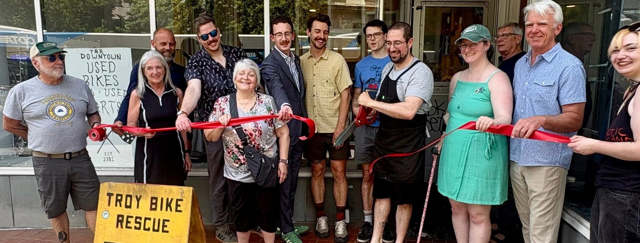 Ribbon cutting at Troy Bike Rescue's downtown location with Council Member McKee and community members